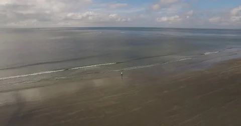 Rolling waves on a cloudy beach with lighthouse Stock Footage 76676757