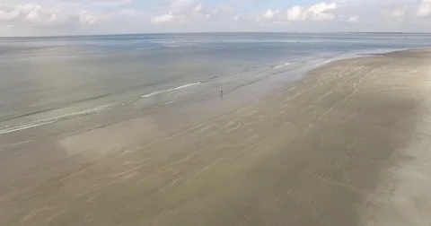 Rolling waves on a cloudy beach with lighthouse Stock Footage 76676817