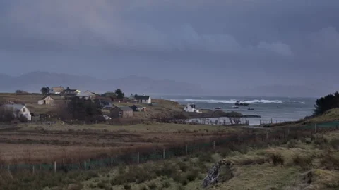 Rolling waves crash on rocky shore during early morning hours near coastline Stock Footage 325936260