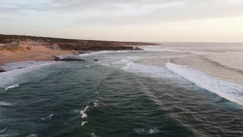 Rolling waves, gentle surf with solitary boat and rocky formations at dawn Stock Footage 344793893
