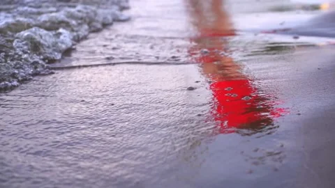 Rolling waves on the sandy shore beach with reflection of a person Stock Footage 197751401