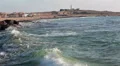 Rolling waves of the sea with lighthouse on hill, Paphos, Cyprus HD Footage