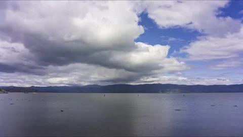 Rolling white and gray clouds reflecting in a lake - timelapse Stock-Footage 219761774