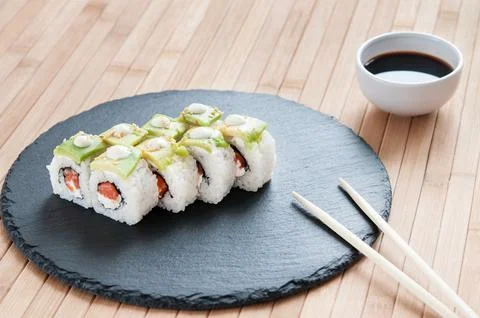 Rolls with avocado on bamboo background. Stock Photos