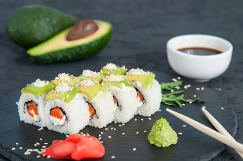Rolls with avocado on black background. Stock Photos