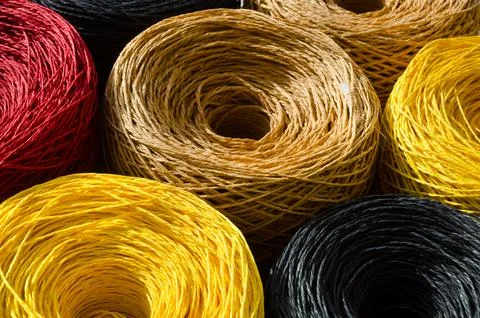 Rolls of colored raffia close-up. Skeins of multi-colored raffia. Stock Photos