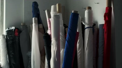 Rolls of cotton are in a warehouse. Different colors of fabric in stock. Stock Footage 238383894