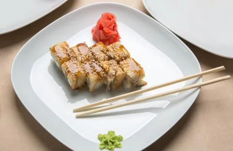 Rolls with eel and ginger on a white plate Stock Photos