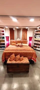 Rolls of fabric displayd on a double bed in a factory shop Foto stock