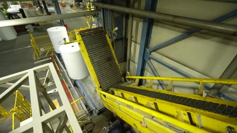 The rolls of finished paper move to the warehouse along the conveyor belt Stockbeeldmateriaal 323068619