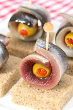 Rolls of herring with olives Stock Photos