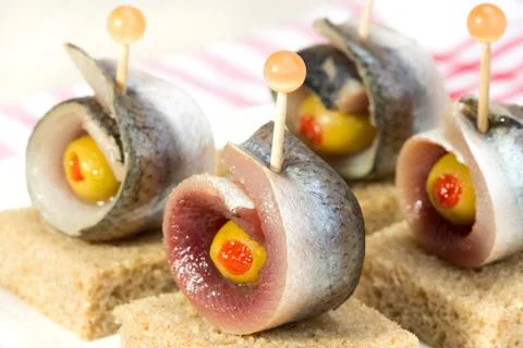 Rolls of herring with olives Stock Photos