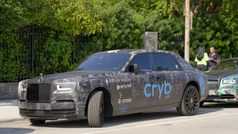 Rolls Royce Wrapped with logos relating to NFTs Stock Footage 177453078