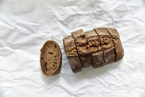 Rolls of rye black bread on white paper 스톡 사진