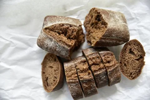 Rolls of rye black bread on white paper 스톡 사진