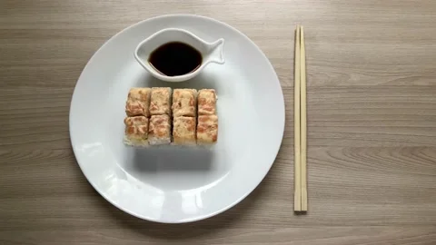 Rolls with salmon on a white plate. Takes a bunch of rolls with his hands Stock Footage 131744872