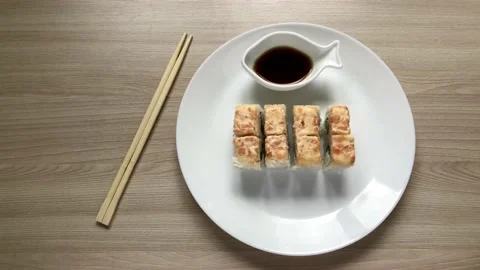 Rolls with salmon on a white plate. Takes sushi with his hands Stock Footage 132393498