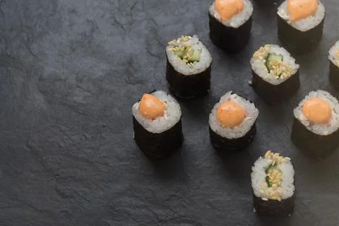 Rolls on a stone platter. Roll with cucumber, cheese sprinkled with sesame seeds Stock Photos