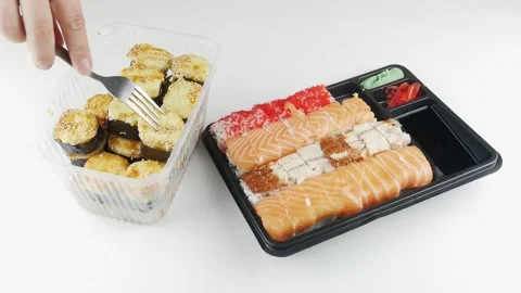 Rolls from the supermarket on the table.Eats sushi with a fork for lunch. Stock-Footage 136564691