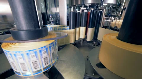 Rolls of tags for bottles. Special machine spins, putting tags on bottles at a 스톡 동영상 94528479