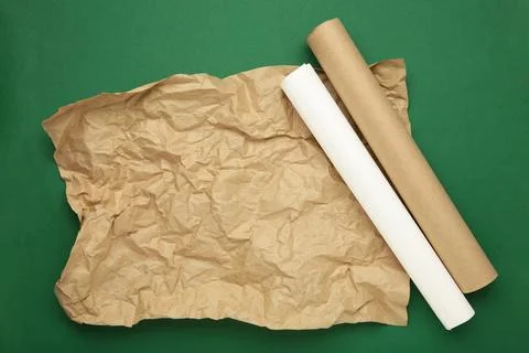 Rolls of white and brown baking paper on green background Stock Photos