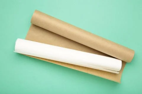 Rolls of white and brown baking paper on mint background Stock Photos