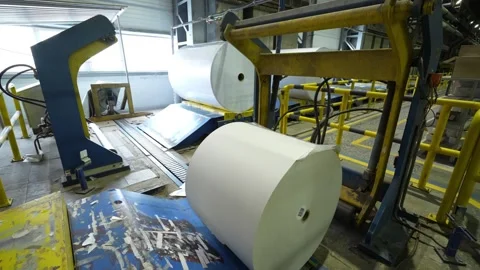 The rolls of white paper are moved along the conveyor belt to the warehouse Stockbeeldmateriaal 301535361