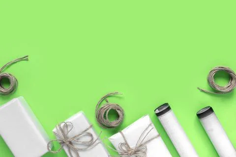 Rolls of wrapping paper, package gift boxes, present eco rope on green vintag Stock Photos