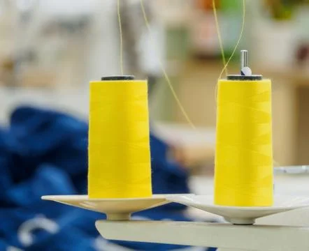 Rolls of yellow cotton thread for sewing with overlock machine. Stock Photos