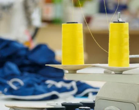 Rolls of yellow cotton thread for sewing with overlock machine. Stock Photos