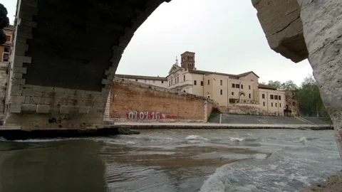 Roman Bridge over Tiber River and the Tiberin Island viewed from the banks Stock Footage 88803067