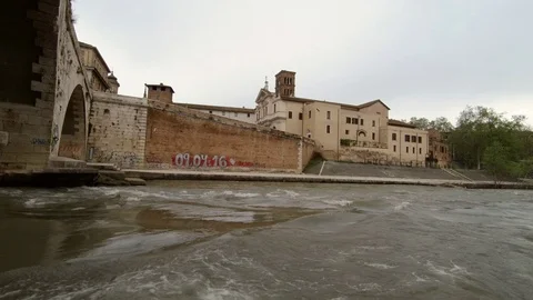 Roman Bridge over Tiber River and the Tiberin Island viewed from the banks Stock Footage 88803272