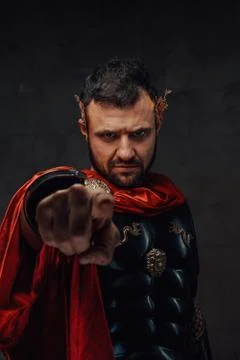 Roman emperor with armour and red mantle points finger Stock Photos