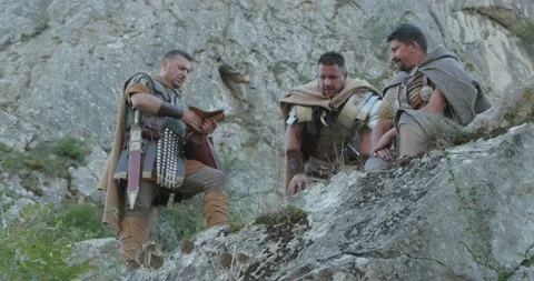 Roman legionaries during a stop at the base of some steep cliffs confused by Stock Footage 154058868