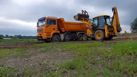 Roman, Romania, 07/7/2021: Loading Dump Truck With Top Soil  Using JCB , 4K Stock Footage 156812712