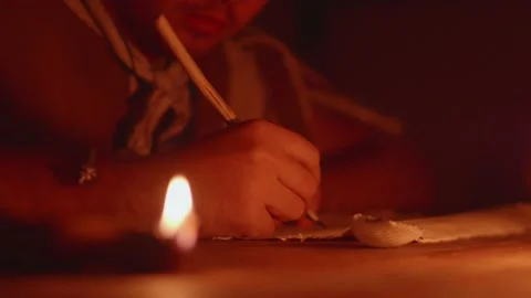 Roman scribe writing in the dim light of the lamp on a papyrus with a wooden Stock-Footage 148259417