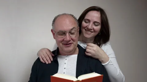 Romance. a man and a middle-aged woman reading a book and laughing Stock Footage 67499523