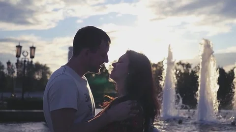Romance of two lovers at the fountain at sunset. HD, 1920x1080. Slow motion Stock Footage 78190894