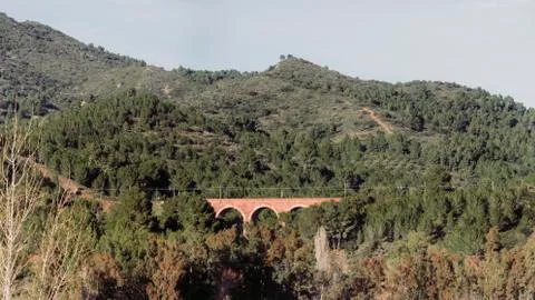 Romanesque bridge for the passage of train between the mountains. Stock Photos