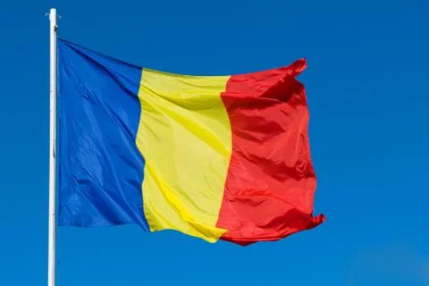 Romania Flag on post moving in the wind. Romanian red, green and blue flag wa Stock Photos