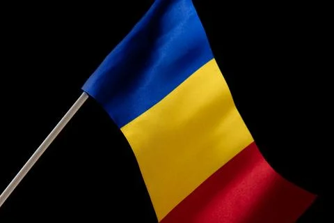 The Romanian flag on a black background developing in the wind Photos