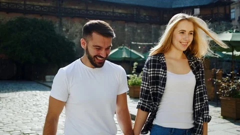 Romantic 30-aged man and woman talking and walking down the street nearby beauti Stock Footage 112348858