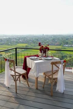 Romantic balcony dinner setup for two with a wide city and landscape view. Stock-Fotos