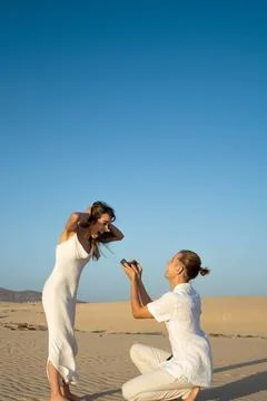 Romantic beach proposal at sunset Stockfoto's