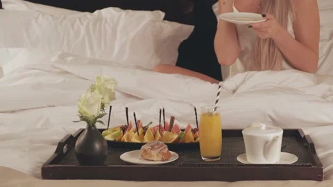 Romantic breakfast in bed, close up of a tray with fruits, juice and a cup of Stock Footage 146611314