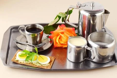 Romantic breakfast in bed. Coffee set, rose, crisp with egg on a silver tray. Stock Photos
