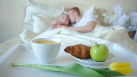 Romantic breakfast in bed, couple on the background out of focus Stock Footage 104462877