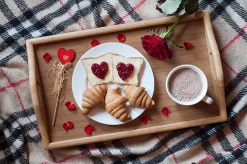 Romantic breakfast in bed for Valentines Day. Toasts with jam, croissants, hot Stock Photos