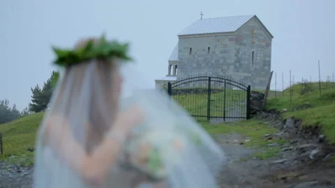 Romantic bride under a veil on the background of a small church. Stock Footage 97773601