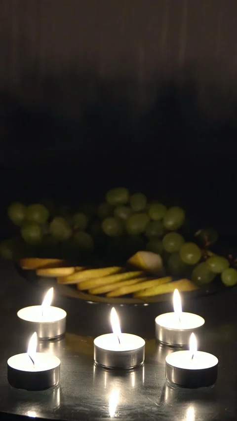 Romantic candlelight dinner with flickering tea light candles, a fruit plate Stock Footage 341579760
